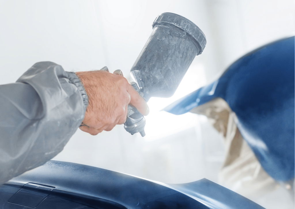 Professional spray painting of a viberant blue car by a skilled technician for exceptional construction and mental health benefits in the UK.